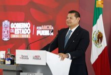Gobernador Alejandro Armenta en conferencia de prensa hablando sobre el convenio del predial en Puebla desde un atril.