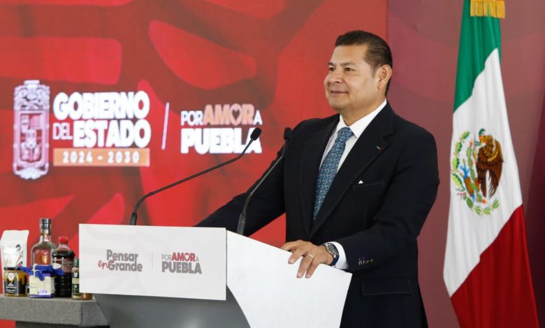 Gobernador Alejandro Armenta en conferencia de prensa hablando sobre el convenio del predial en Puebla desde un atril.