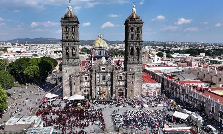 Toma aérea de la masiva Procesión de Viernes Santo en el centro histórico de Puebla, miles de personas llenan las calles alrededor de la Catedral