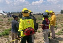 Aeronave siniestrada modelo Cessna 172 matrícula XB-RRN en terrenos de cultivo de Santa Ana Xalmimilulco, Puebla, rodeada por elementos de Protección Civil y cuerpos de emergencia tras el desplome.