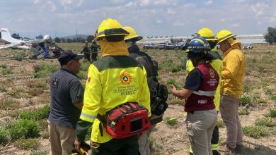 Aeronave siniestrada modelo Cessna 172 matrícula XB-RRN en terrenos de cultivo de Santa Ana Xalmimilulco, Puebla, rodeada por elementos de Protección Civil y cuerpos de emergencia tras el desplome.