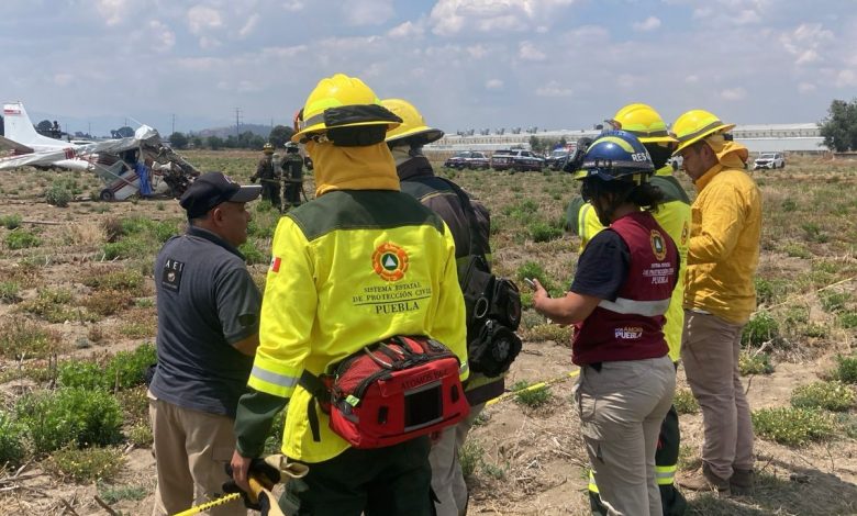 Aeronave siniestrada modelo Cessna 172 matrícula XB-RRN en terrenos de cultivo de Santa Ana Xalmimilulco, Puebla, rodeada por elementos de Protección Civil y cuerpos de emergencia tras el desplome.