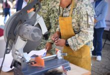 Fotografía de un módulo de canje de armas en una plaza pública. Se observa a personal militar