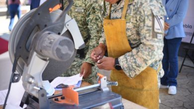 Fotografía de un módulo de canje de armas en una plaza pública. Se observa a personal militar