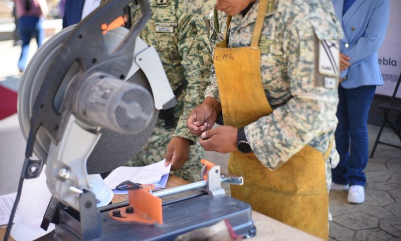 Fotografía de un módulo de canje de armas en una plaza pública. Se observa a personal militar
