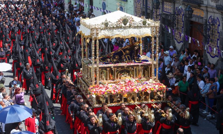 Fieles católicos acompañan la imagen del Señor de las Maravillas durante la Procesión de Viernes Santo en el Centro Histórico de Puebla.