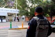 Oficial de la Policía Estatal de Puebla de espaldas, portando chaleco táctico, vigilando la entrada del Centro Escolar Niños Héroes de Chapultepec ante operativos por retos virales.