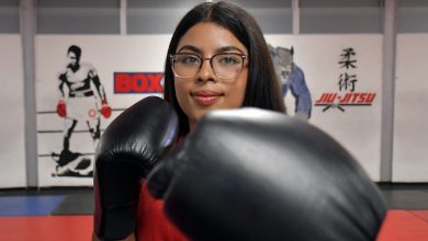 Fotografía de primer plano de la boxeadora Fátima Ramos de la BUAP, portando uniforme deportivo y con el guante de boxeo extendido hacia el frente en posición de guardia