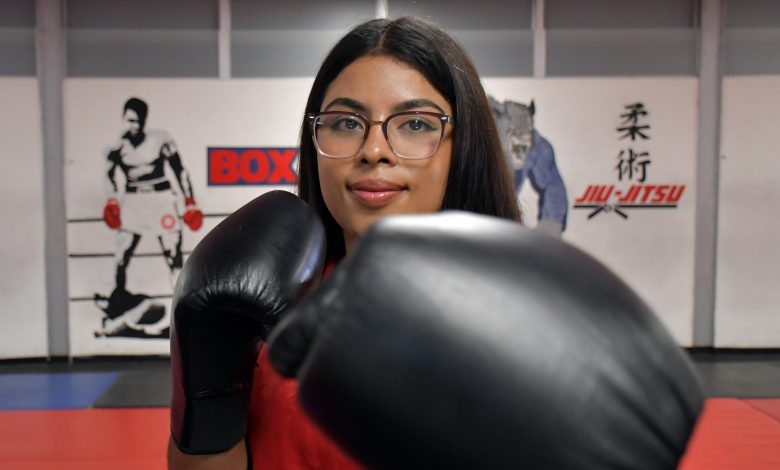 Fotografía de primer plano de la boxeadora Fátima Ramos de la BUAP, portando uniforme deportivo y con el guante de boxeo extendido hacia el frente en posición de guardia