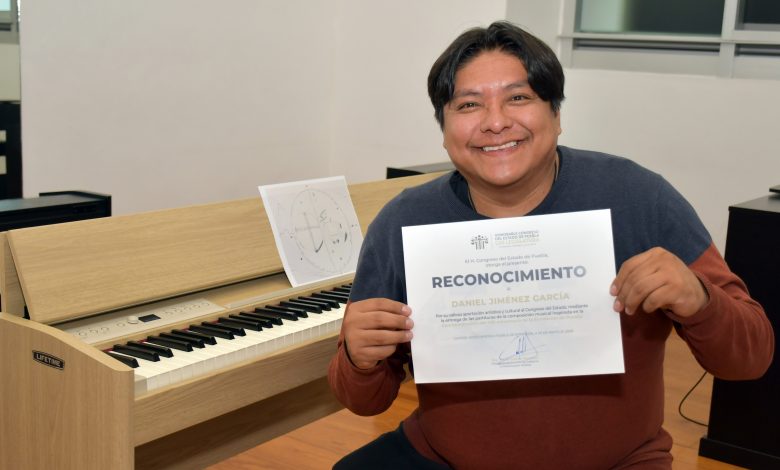 Daniel Jiménez García, compositor del CCU-BUAP, muestra el reconocimiento del Congreso de Puebla por su partitura conmemorativa del 495 aniversario de la ciudad.