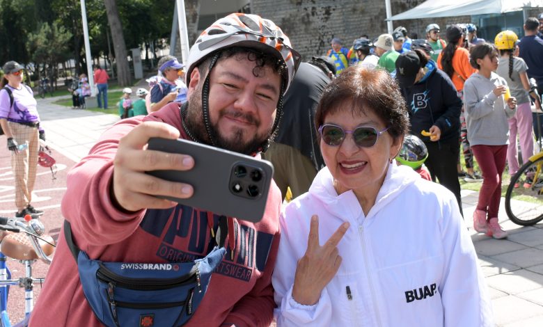 La Rectora de la BUAP, Lilia Cedillo Ramírez, posa para una selfie con un participante durante la rodada del Día del Padre en Ciudad Universitaria.