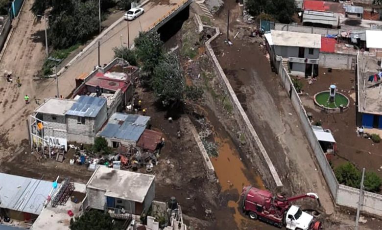 Vista aérea de zona afectada en La Gloria, Ciudad Serdán, con camión de limpieza y lodo en canal