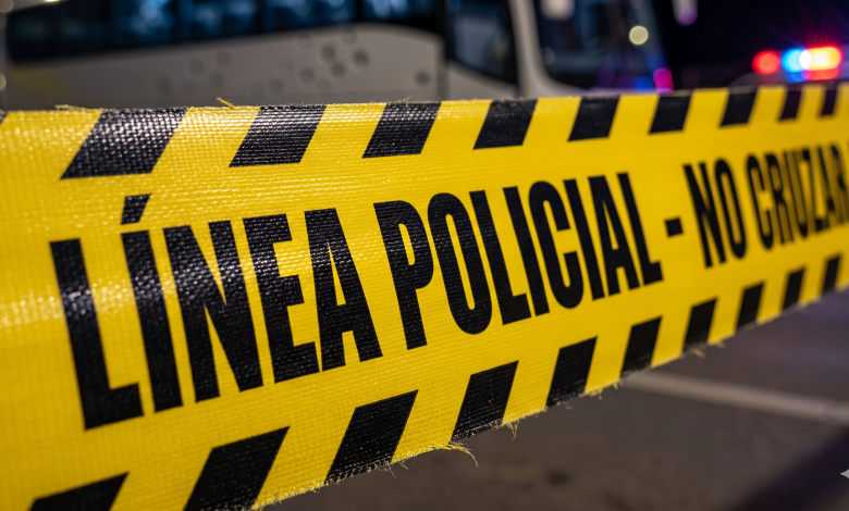 Cinta de línea policial amarilla y negra frente a un autobús de noche