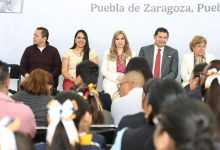 Evento de entrega de constancias del programa Familias Fuertes en Puebla, con funcionarios estatales y familias beneficiadas al frente.