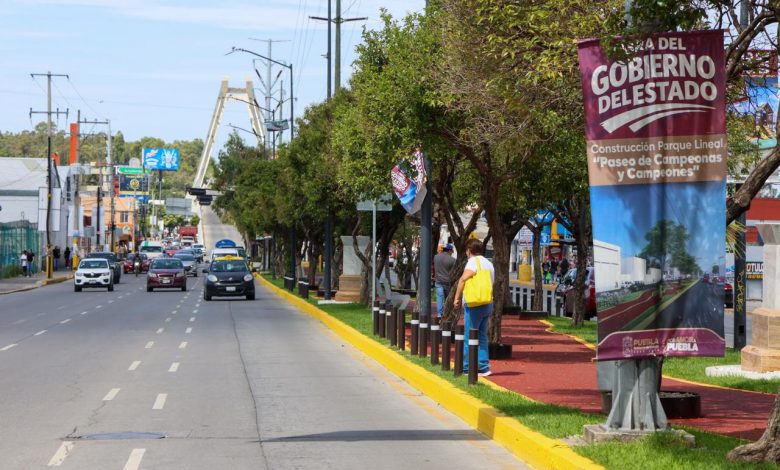 Vialidad rehabilitada en el Paseo de Campeonas y Campeones en Puebla, con señalización del Gobierno del Estado sobre construcción del parque lineal