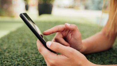 Joven usando smartphone al aire libre, imagen que ilustra el uso de redes sociales y el riesgo de ciberacoso