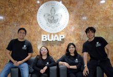 Los cuatro integrantes de Protavia, startup de estudiantes BUAP, posan frente al escudo de la universidad.