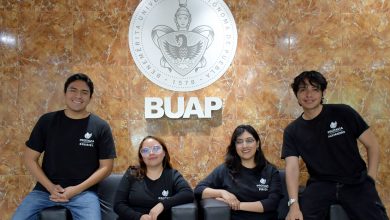 Los cuatro integrantes de Protavia, startup de estudiantes BUAP, posan frente al escudo de la universidad.