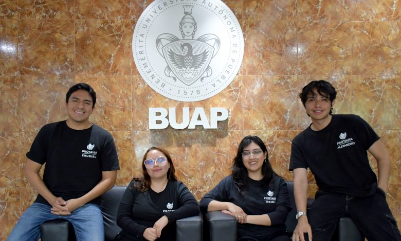 Los cuatro integrantes de Protavia, startup de estudiantes BUAP, posan frente al escudo de la universidad.