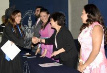 La rectora de la BUAP, Lilia Cedillo Ramírez, estrecha la mano de una egresada con toga y birrete durante la graduación de la Preparatoria de Izúcar de Matamoros.
